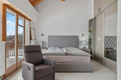 a bedroom with a bed and a chair at Magnificent mountain home - 756 in Crans-Montana