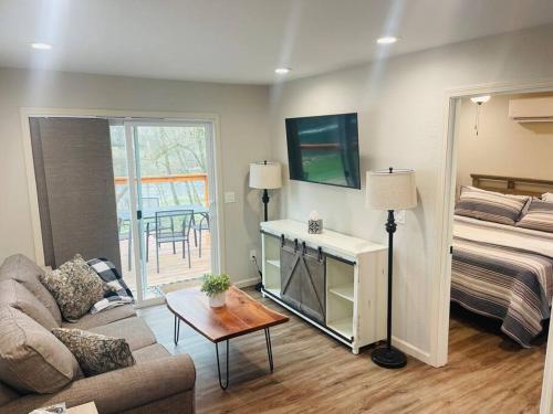 un soggiorno con un letto e un divano di Deluxe Cabin 5 - Rogue River Resort a Grants Pass
