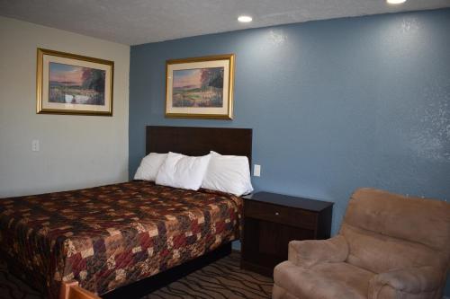 a hotel room with a bed and a chair at Americas Best Value Inn Marion in Marion
