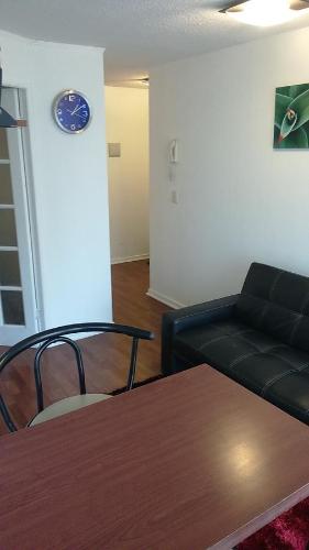 a living room with a black couch and a table at Departamento Paseo Bulnes Metro La Moneda in Santiago
