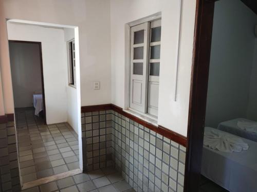 a bathroom with a window and a tiled hallway at Pousada Belo Mar in Salvador