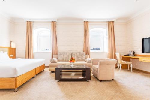 1 dormitorio con 1 cama y sala de estar en Praga Hotel, en Tashkent