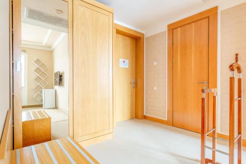 a bathroom with a wooden door and a walk in shower at Praga Hotel in Tashkent