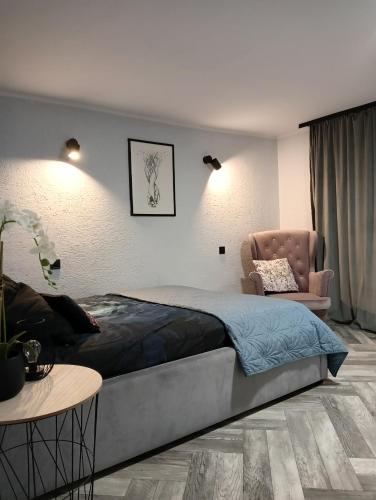 a bedroom with a large bed and a chair at Pod Kasztanami blisko A2 