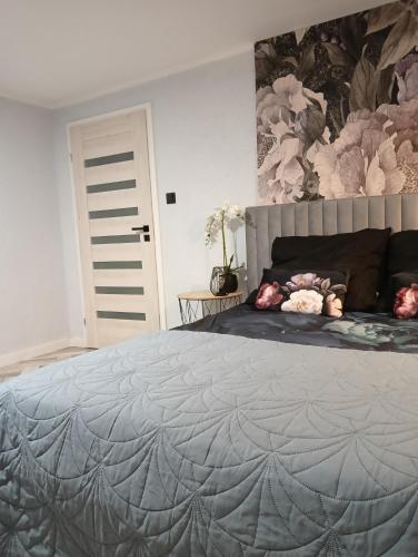 a bedroom with a large bed with a gray quilt at Pod Kasztanami blisko A2 in Baranów