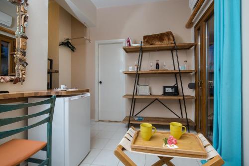 a small kitchen with a table and yellow cups at Arodamos Studios & Apts in Kissamos