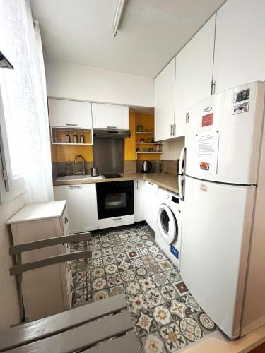 een keuken met een koelkast, een wasmachine en een droger bij Studio lumineux aux portes de Paris in Clichy