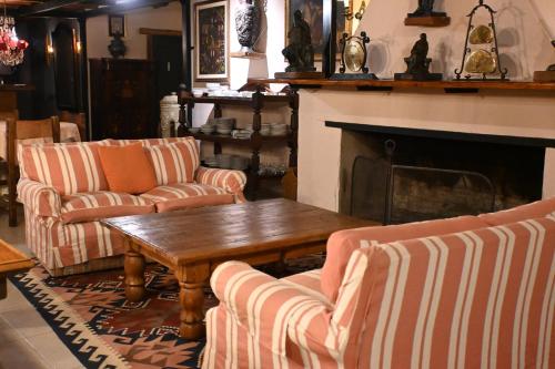 a living room with couches and a table and a fireplace at Hotel La Castellana in Paysandú