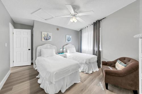 sypialnia z 2 łóżkami i krzesłem w obiekcie Crystal Village 16B is a 2 Bed 2 bath Condo near the Beach that sleeps 6 w mieście Destin