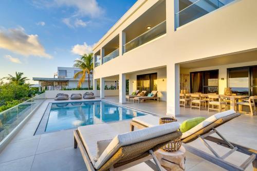 a villa with a swimming pool and a house at Tres Ojos in Sabadeco in Kralendijk