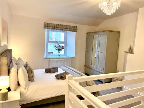ein kleines Schlafzimmer mit einem Bett und einem Fenster in der Unterkunft Blossom Tree Cottage in Barnoldswick