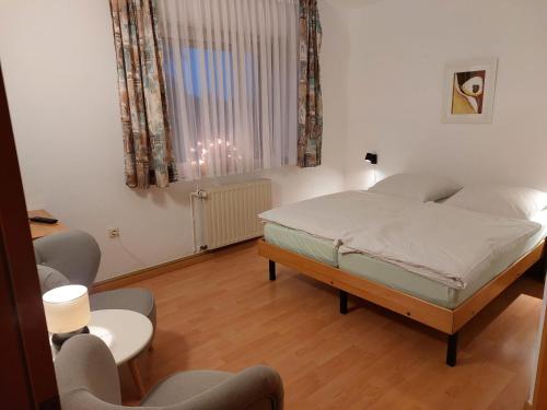 a bedroom with a bed and a table and chairs at Pension Britta in Roetgen