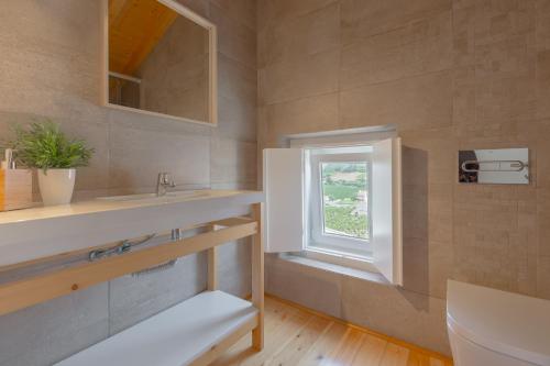 uma casa de banho com um lavatório e uma janela em Retiro do Castelo em Óbidos