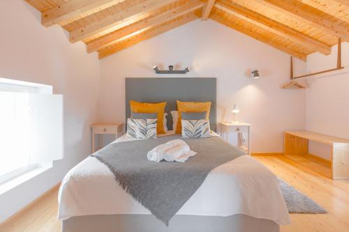 a bedroom with a large bed with wooden ceilings at Retiro do Castelo in Óbidos