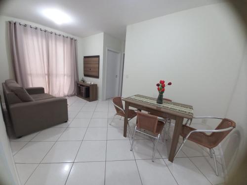 sala de estar con mesa, sillas y sofá en Apto de dois quartos com uma suíte, en Palhoça