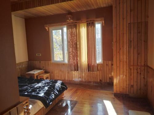 a bedroom with a bed and a large window at Forest Walk Cottage by Livingstone in Shimla