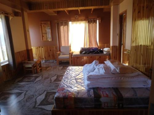 ein Schlafzimmer mit einem Bett in einem Zimmer mit einem Fenster in der Unterkunft Forest Walk Cottage by Livingstone in Shimla