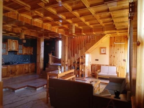 una sala de estar con paredes de madera y una escalera. en Forest Walk Cottage by Livingstone, en Shimla