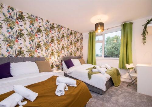 two beds in a room with green curtains at Coventry Michaelmas Pet Friendly 2 Bedroom Apartment in Parkside