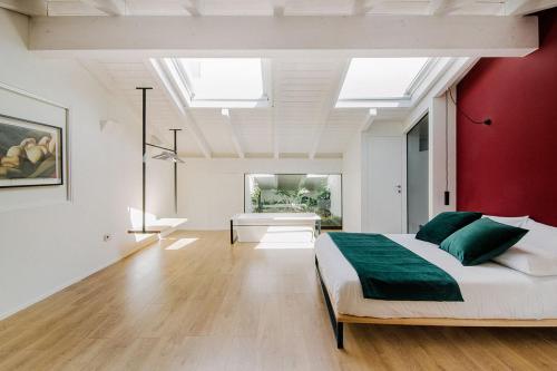 a bedroom with a large bed and a red wall at Via Del Centro Guesthouse in Oristano