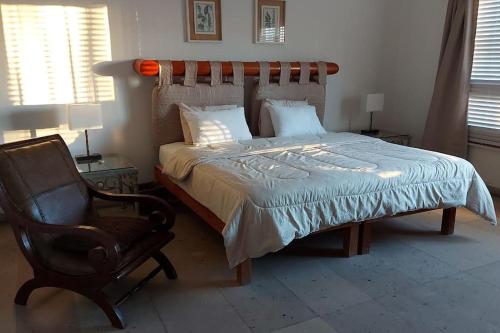 a bedroom with a bed and a chair and a chair at Casa grande en Bahia de Kino frente al mar in Bahía Kino