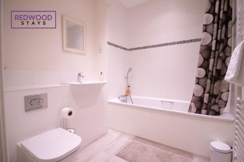 a bathroom with a toilet and a tub and a sink at Festival Place, Modern Town Center Apartment, Perfect for Contractors & Families, FREE Parking & WiFi by REDWOOD STAYS in Basingstoke