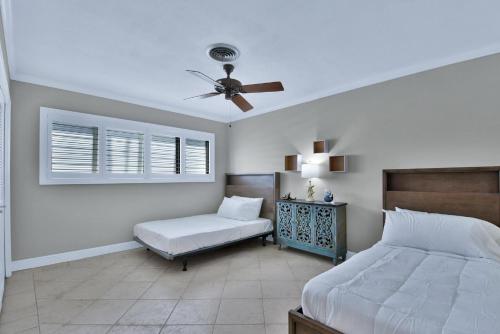 a bedroom with a bed and a ceiling fan at Zen Pool Home in Lighthouse Point