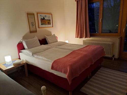 a bedroom with a large bed with a red blanket at Haus Margrit Ferienwohnung in Sonnenlage in Golling an der Salzach