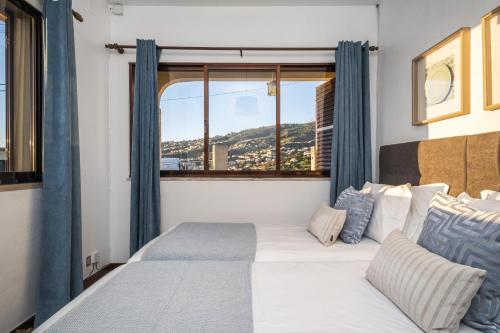 1 dormitorio con 1 cama grande y ventana en White Rabbit II by Madeira Sun Travel, en Calheta