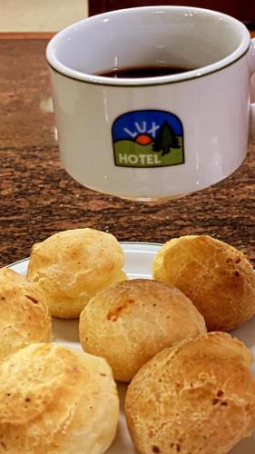 a plate of biscuits next to a cup of coffee at Hotel Lux in Poços de Caldas