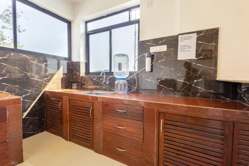 a kitchen with a sink and a window at Apricot Service Apartments in Palolem