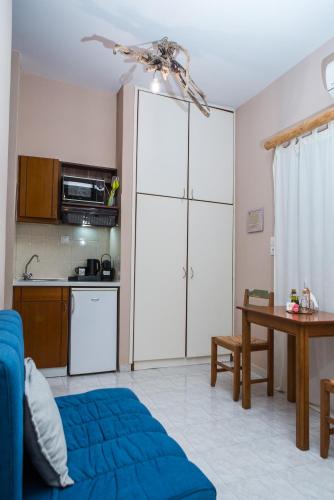 a living room with a blue bed and a kitchen at Arodamos Studios & Apts in Kissamos