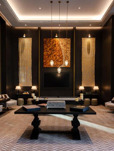 a living room with a television and a table at Raffles Al Areen Palace Bahrain in Manama