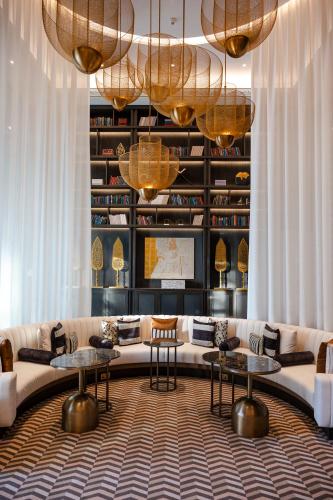 a living room with a large couch and tables at Raffles Al Areen Palace Bahrain in Manama