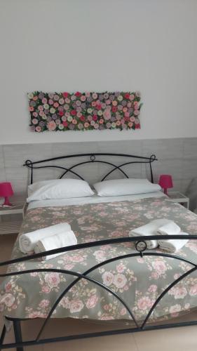 a bedroom with a bed with flowers on the wall at Dimora Filangieri in Naples