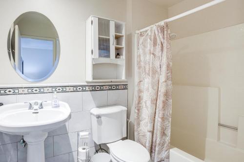 a bathroom with a toilet and a sink and a mirror at Walk to Dtwn Palm Springs Condo with Pool Access in Palm Springs