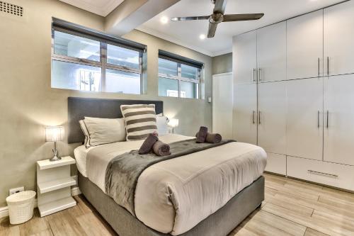 a bedroom with a large bed with white cabinets at Apartment on Graham in Cape Town