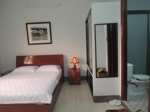 ein Schlafzimmer mit einem großen Bett und einem Spiegel in der Unterkunft Sao Mai Hotel in Cái Bè