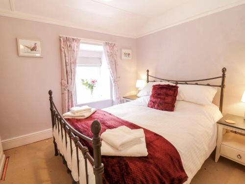 um quarto com uma cama grande e uma janela em 5 Gwynant Street em Caernarfon