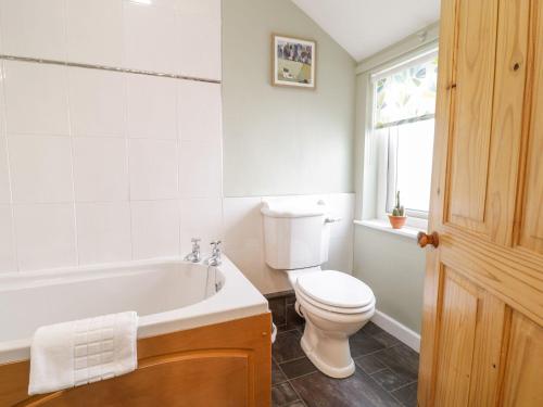 uma casa de banho com um WC, uma banheira e um lavatório. em 5 Gwynant Street em Caernarfon