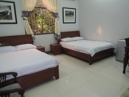 a bedroom with two beds and a window at Sao Mai Hotel in Cai Be