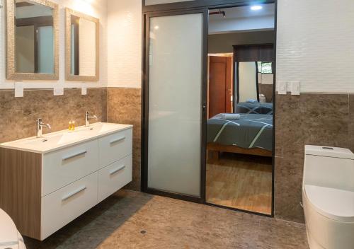 a bathroom with a sink and a toilet and a bedroom at Hotel Precursores in Lima