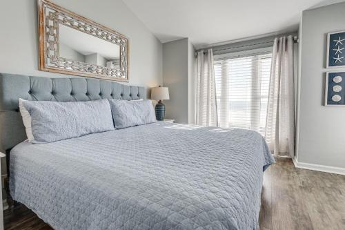 een slaapkamer met een groot bed en een spiegel bij Sunny Seaside Condo with View - Walk to Beach in Myrtle Beach