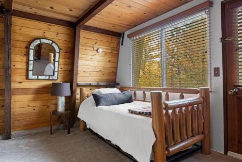 um quarto com uma cama num quarto com paredes de madeira em Alta Vista Haus in Moonridge em Big Bear Lake