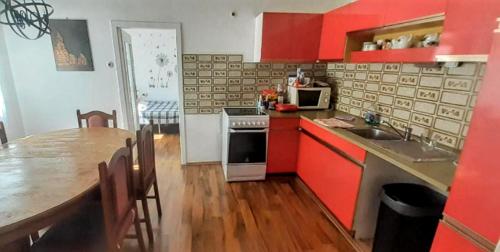 a kitchen with red cabinets and a table and a counter top at Villa Fortuna Romantik in Lackenhof