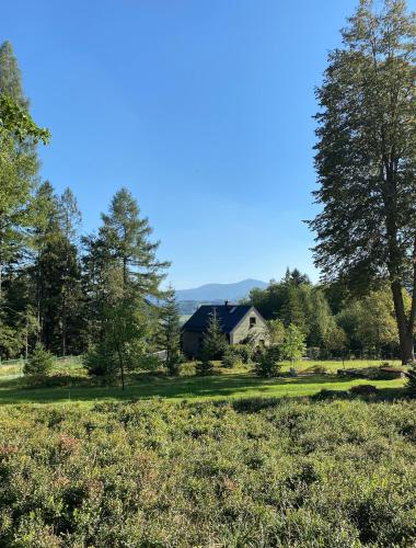 a house in the middle of a field with trees at LaČeladná - Tinystudio in Čeladná