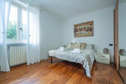um quarto branco com uma cama e uma janela em Desenzanino Lakeside - 1 min from the beach em Desenzano del Garda
