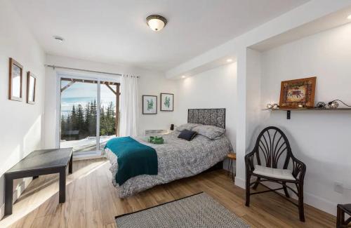 Schlafzimmer mit einem Bett, einem Schreibtisch und einem Fenster in der Unterkunft Oasis by the River in Saint-Irénée