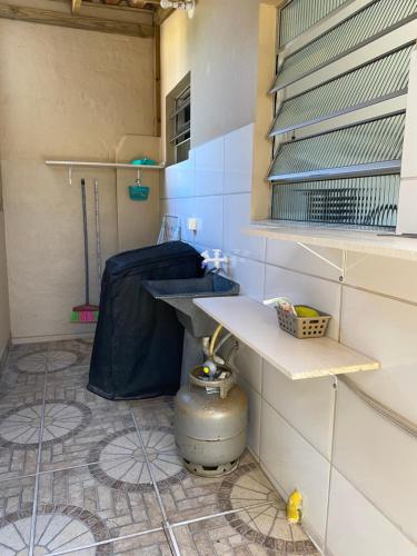 Habitación con cocina con mesa y suelo de baldosa. en Apartamento encantador cachoeira en Florianópolis