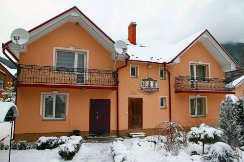 uma casa com neve no chão em frente dela em Zoriana em Tatariv